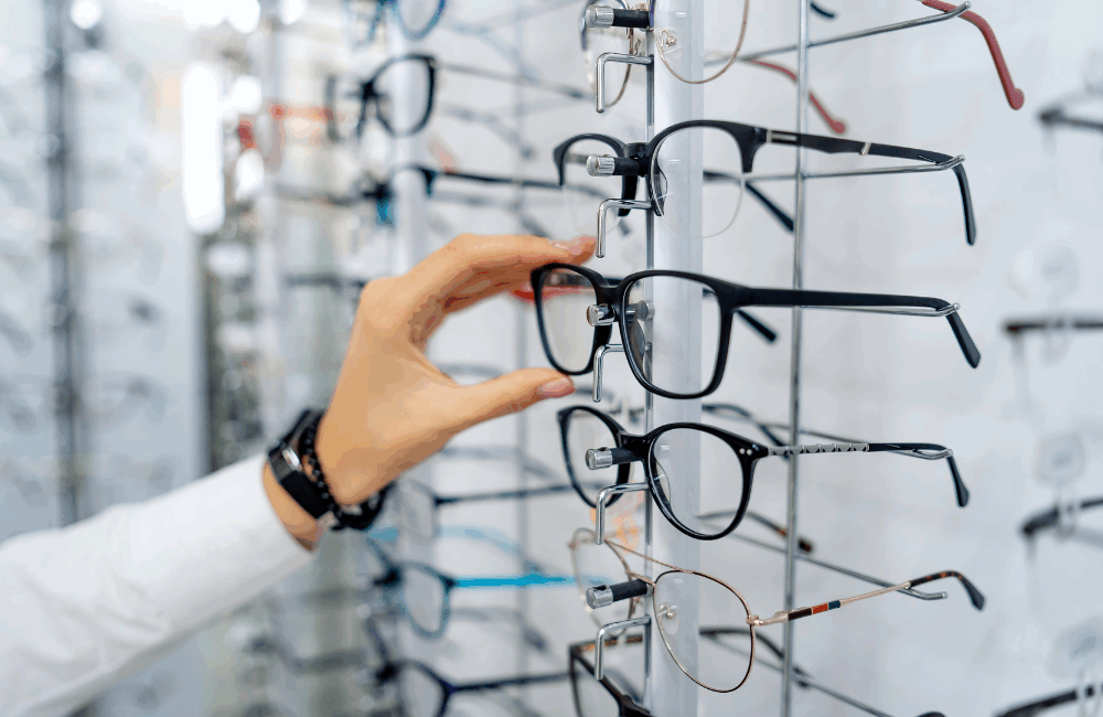 Kuvituskuva, kuvassa silmälasikehyksiä optikkoliikkeen hyllyssä.