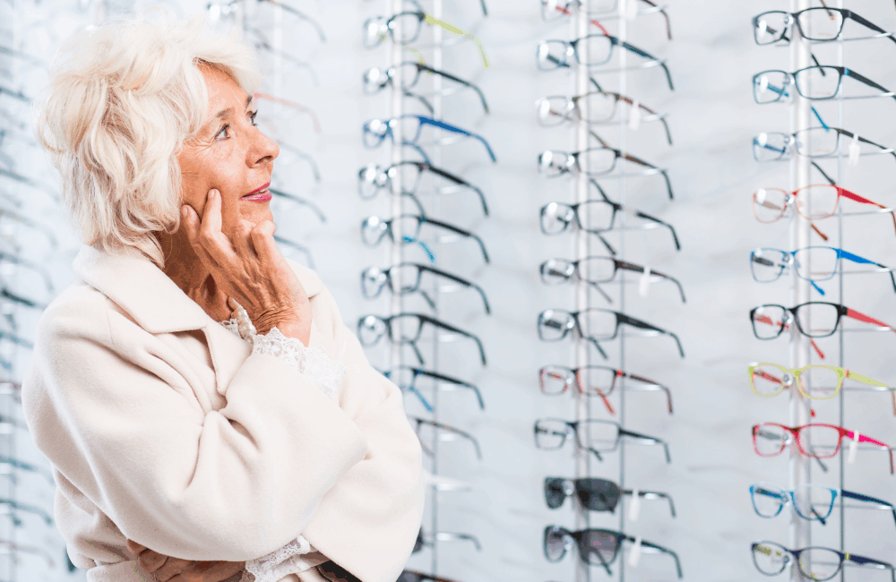 Nainen katselee kehyksiä optikkoliikkeessä.