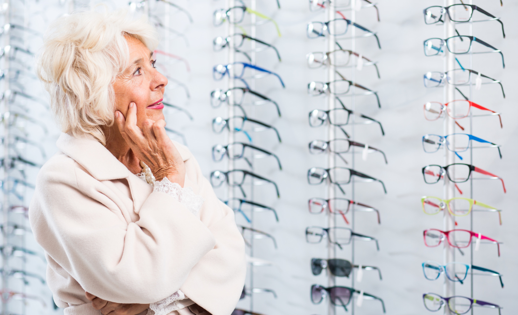 Nainen katselee kehyksiä optikkoliikkeessä.