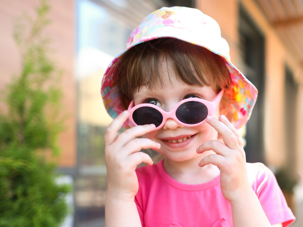 Happy smiling girl child in sunglasses outdoor portrait.