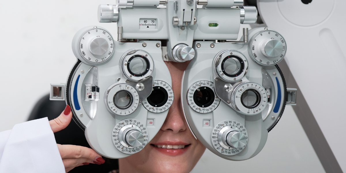 Optometristi tutkii naisen näköä tutkimuslaitteella.